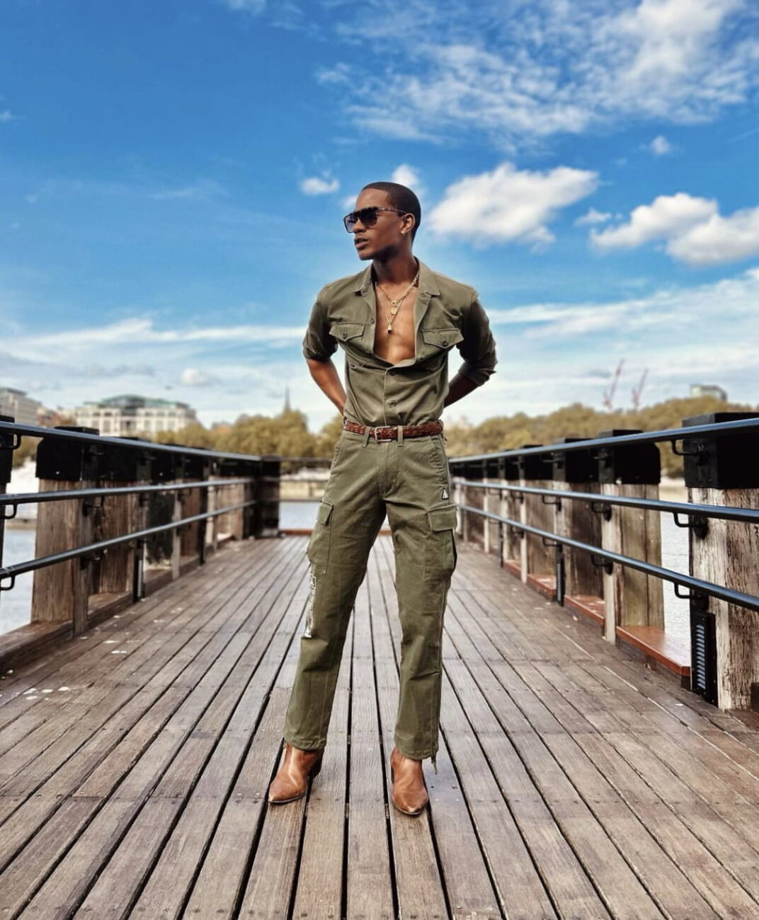 Denola Grey effortlessly rocking an army green jumpsuit, showcasing his cool and casual style.