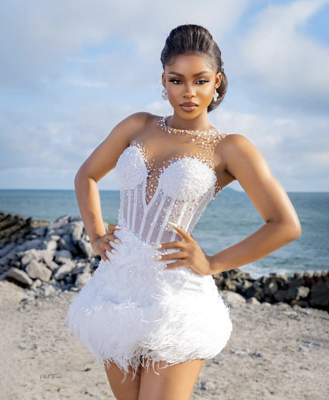 Priscilla Ojo in a white corset dress with beads attached around the top.