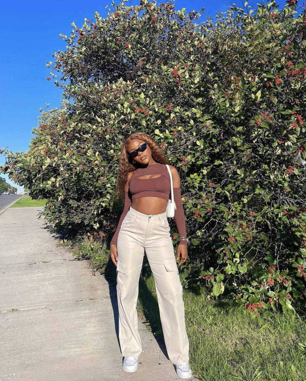 Stephanie Moka in a brown crop top and combat trousers.