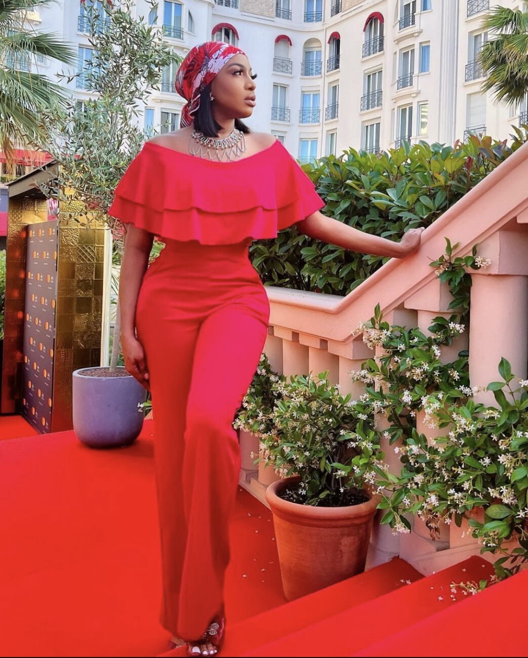 Chika Ike in an off-shoulder red jumpsuit.