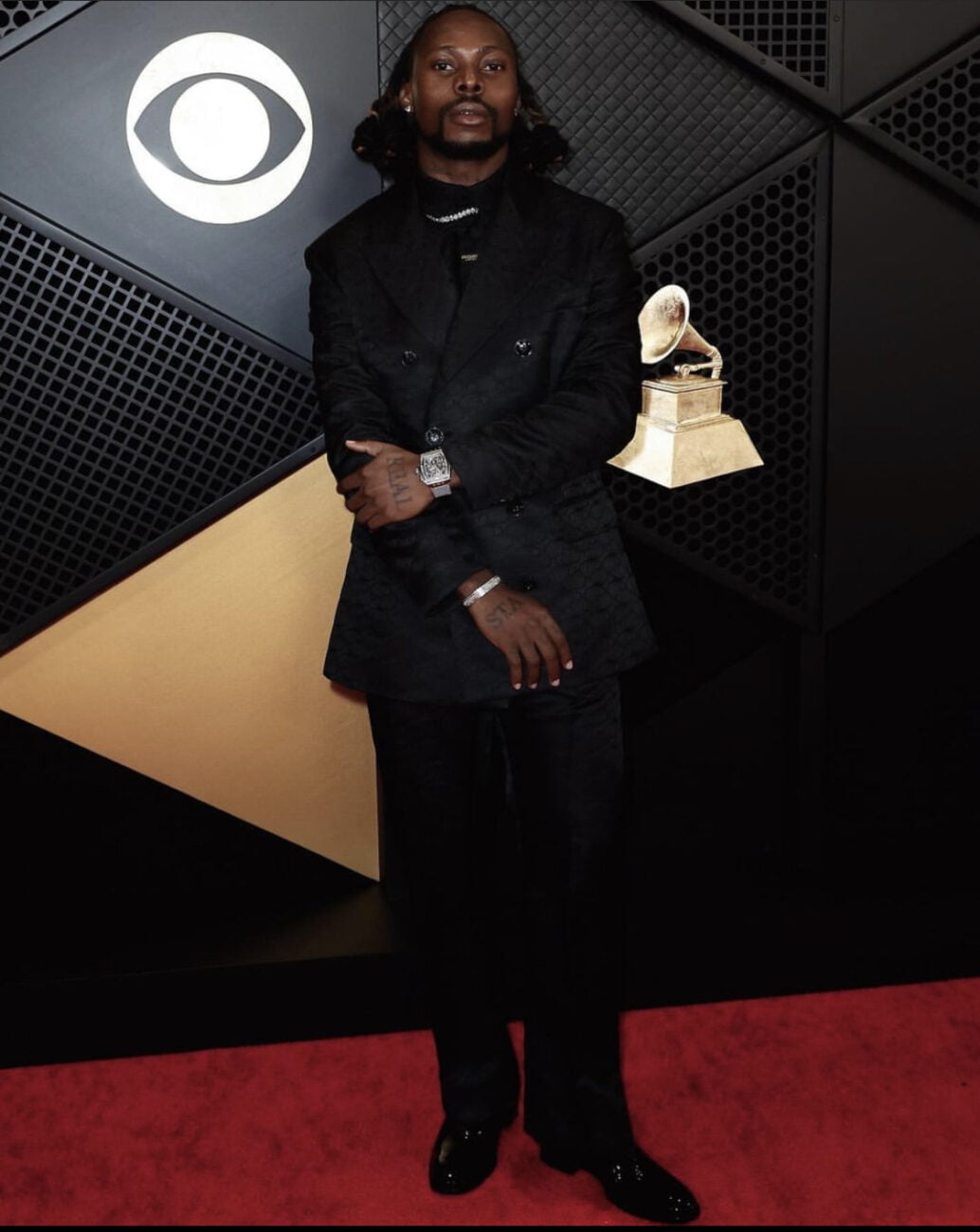 Asake rocks simple black suit to the Grammys 2024.