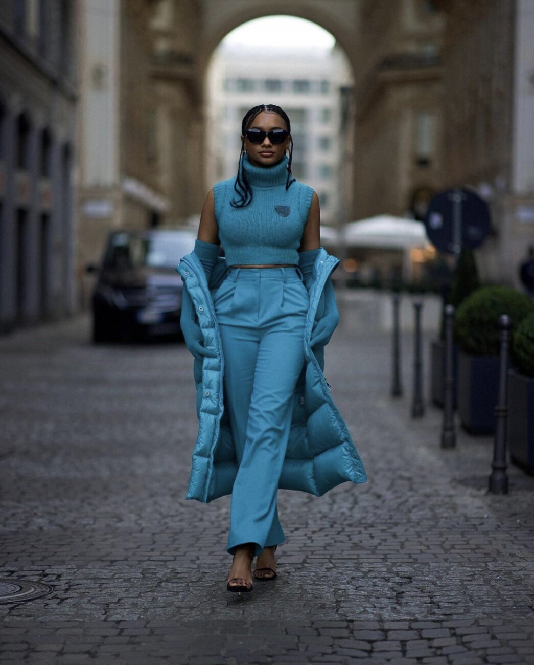 Temi Otedola in a blue turtle neck top, paired with matching trousers, and blue puffer jacket.