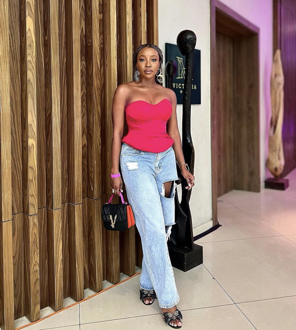 Ini Dima-Okojie in a pink corset dress, paired with denim trousers.